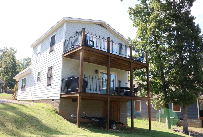 Back of property featuring a wooden deck and a yard