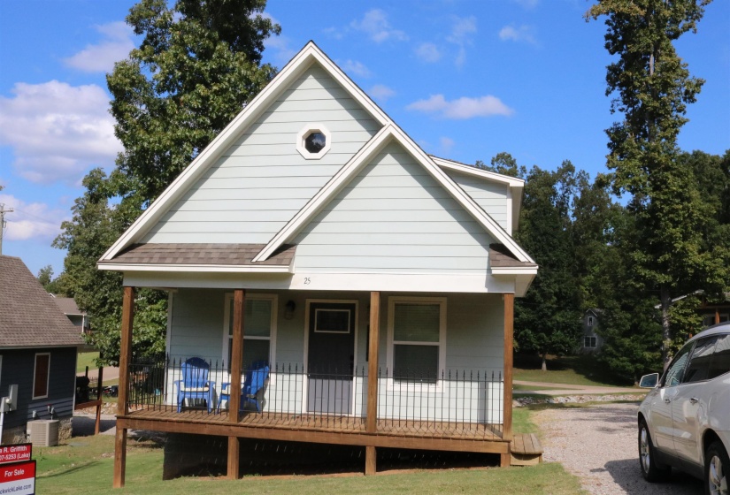 View of front of home featuring central air condition unit, a porch, and a front yard