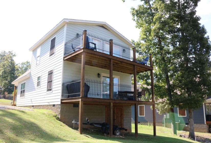 Back of property featuring a lawn and a wooden deck