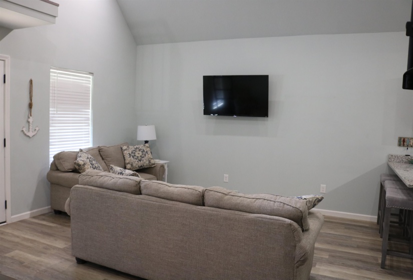 Living room featuring hardwood / wood-style flooring and vaulted ceiling
