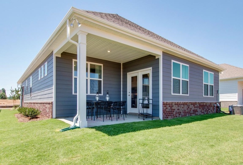 Rear view of property with a yard and a patio