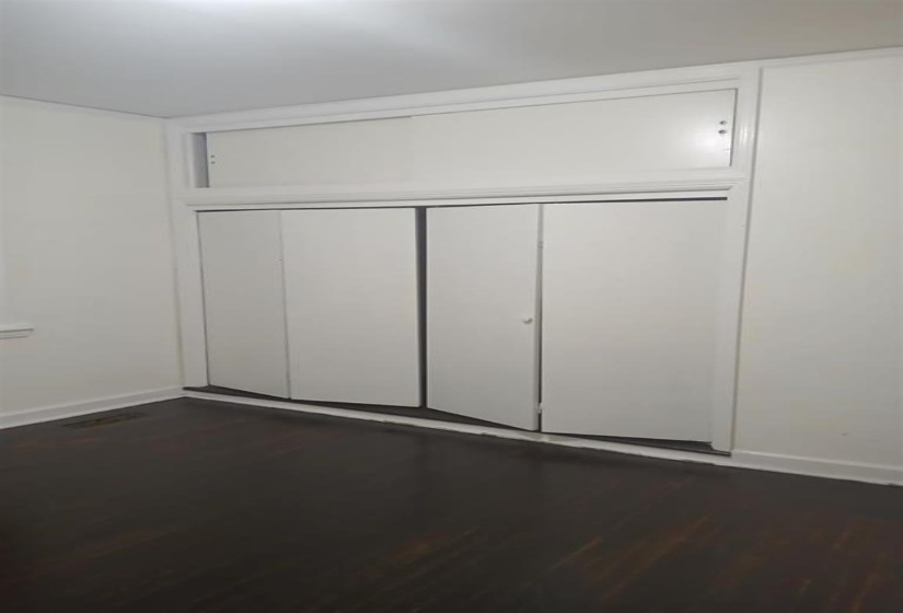 Unfurnished bedroom with dark wood-type flooring and a closet