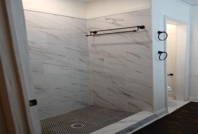 Bathroom featuring tiled shower and hardwood / wood-style floors