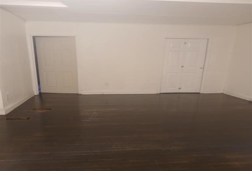 Unfurnished room with dark wood-type flooring