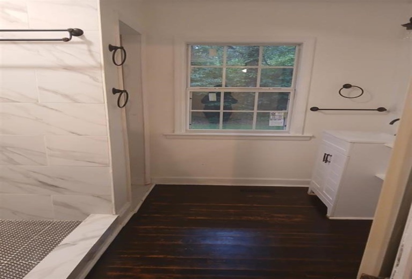 Bathroom with hardwood / wood-style flooring and a shower