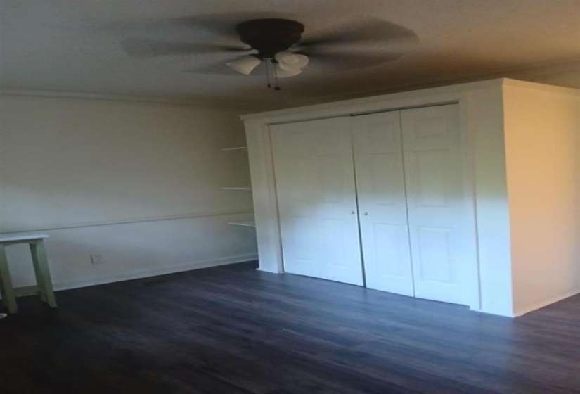 Unfurnished bedroom with a closet, ceiling fan, and dark hardwood / wood-style flooring