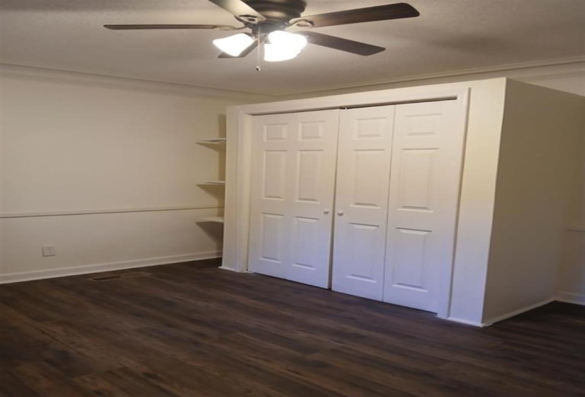 Unfurnished bedroom featuring a closet, ceiling fan, and dark hardwood / wood-style flooring