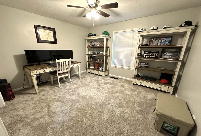 Carpeted office space featuring ceiling fan