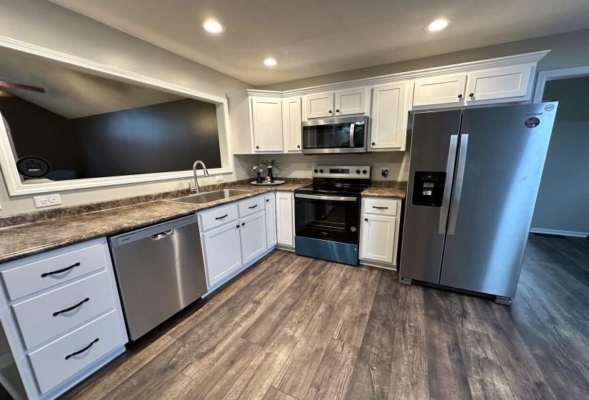 Kitchen featuring white cabinetry, sink, ceiling fan, dark wood-type flooring, and appliances with stainless steel finishes