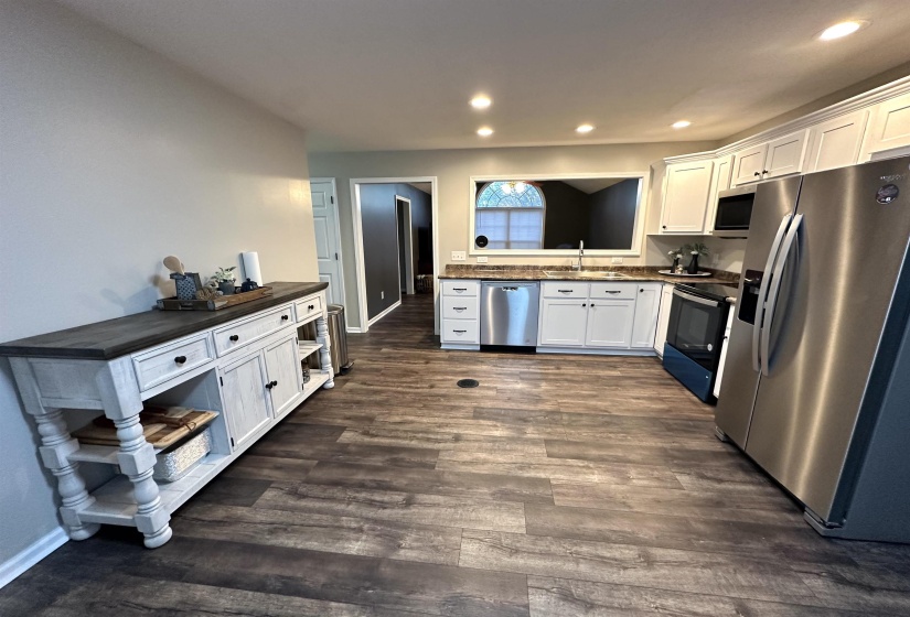 Kitchen featuring dark hardwood / wood-style flooring, white cabinetry, sink, and appliances with stainless steel finishes
