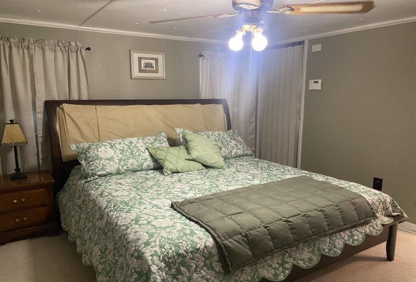 Bedroom featuring carpet, crown molding, and a ceiling fan