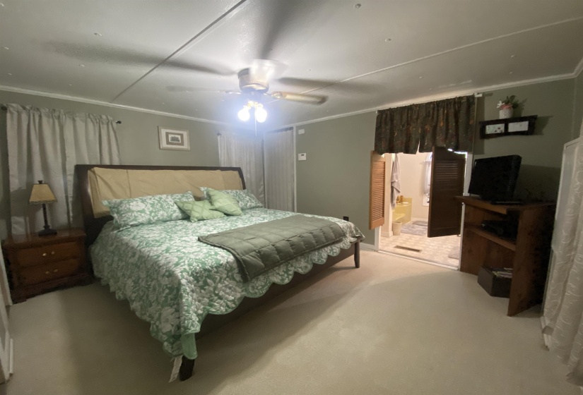 Bedroom featuring crown molding, carpet, and a ceiling fan