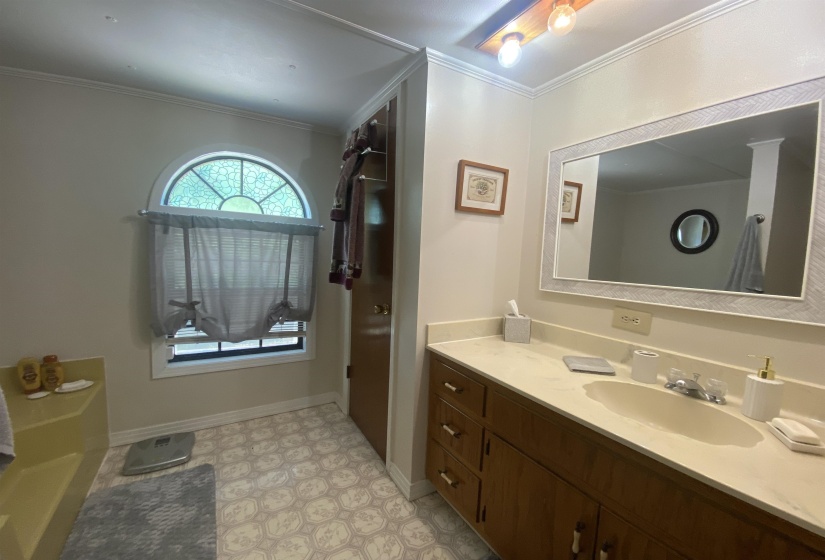 Bathroom with vanity, crown molding, and tile patterned floors