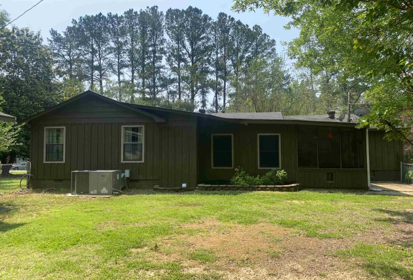 Rear view of property with board and batten siding and a sunroom