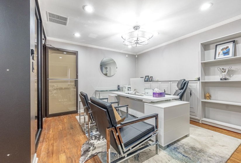 Home office with built in features, light hardwood / wood-style flooring, ornamental molding, and a chandelier