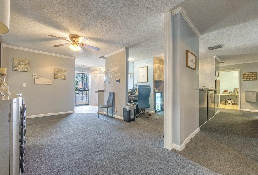 Interior space featuring ornamental molding, carpet floors, and a textured ceiling