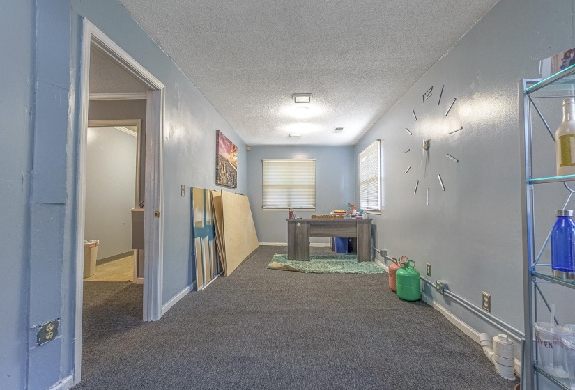 Corridor with carpet flooring and a textured ceiling