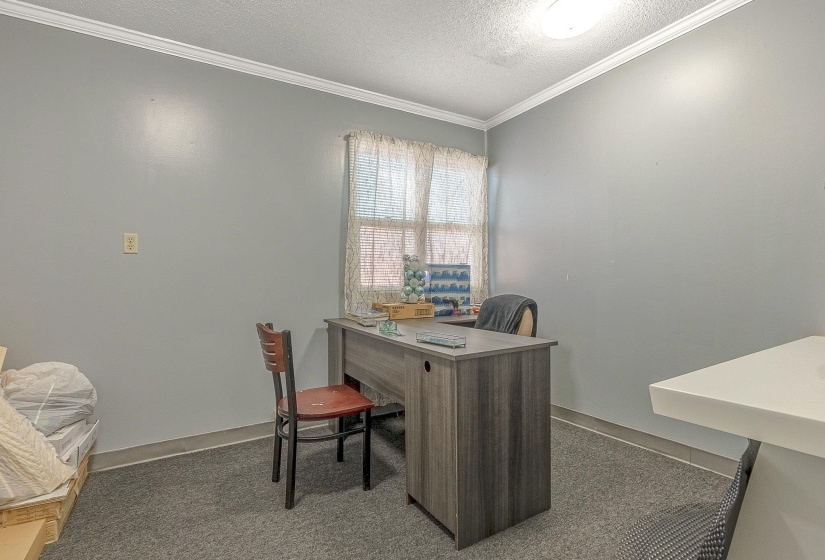 Office featuring crown molding, dark carpet, and a textured ceiling