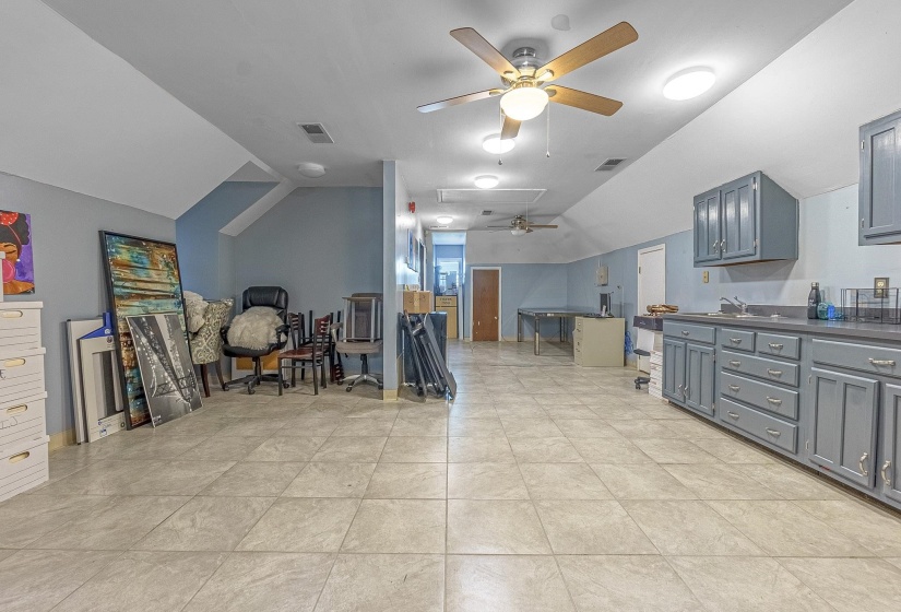 Interior space featuring lofted ceiling, sink, gray cabinetry, and ceiling fan