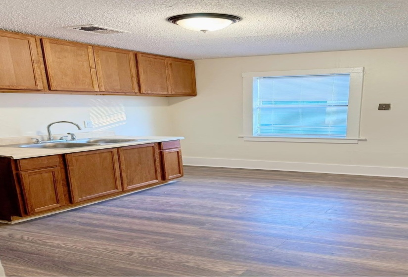 Kitchen featuring a textured ceiling, sink, and dark wood-type flooring