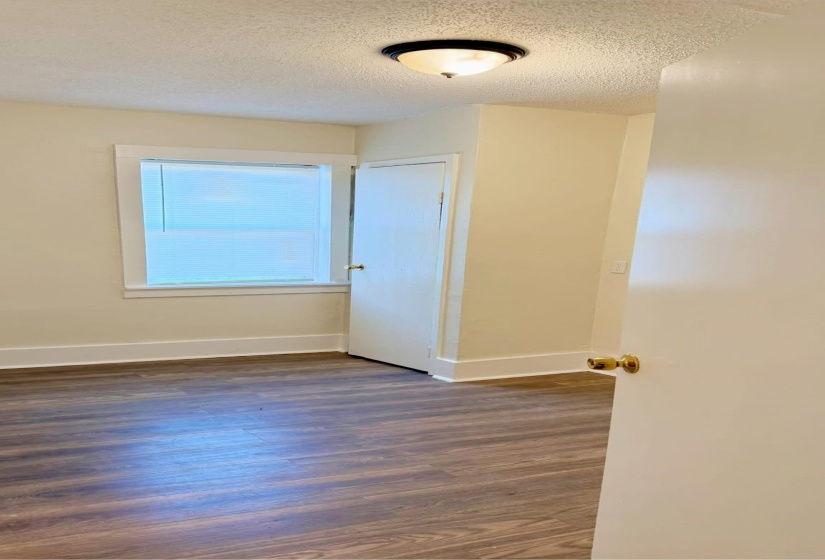 Unfurnished room featuring a textured ceiling and dark hardwood / wood-style flooring