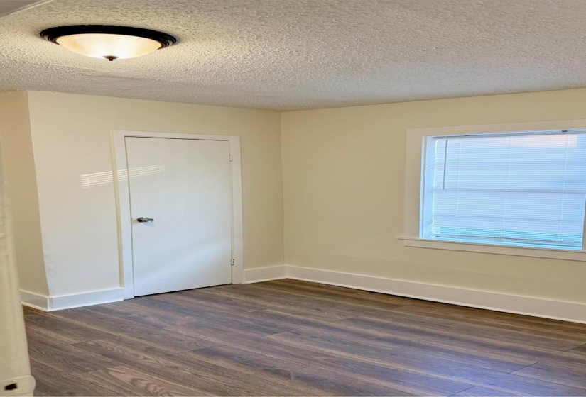 Unfurnished room with a textured ceiling and dark hardwood / wood-style flooring