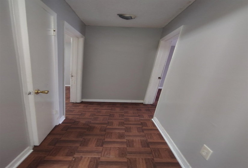 Hallway featuring dark parquet flooring