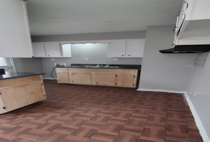 Kitchen featuring white cabinets, sink, dark parquet floors, and a textured ceiling