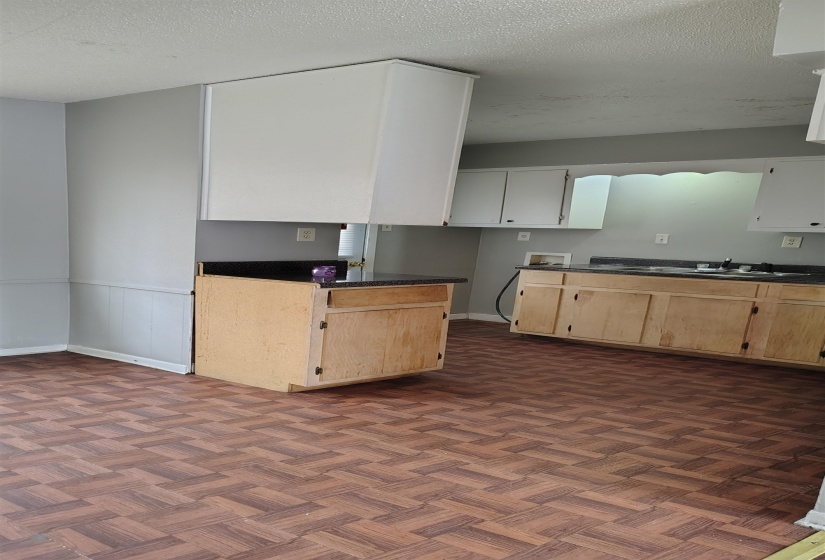 Kitchen with a textured ceiling and light brown cabinetry