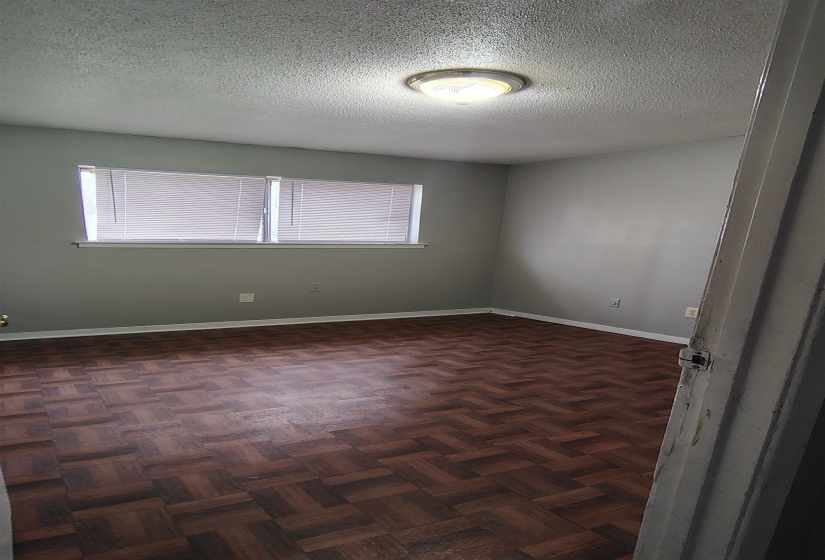 Spare room with dark parquet floors and a textured ceiling