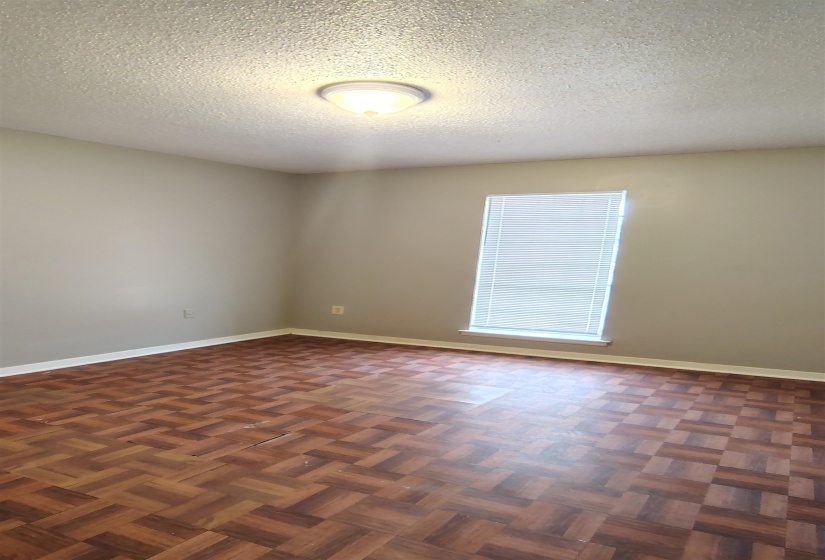 Unfurnished room with dark parquet flooring and a textured ceiling