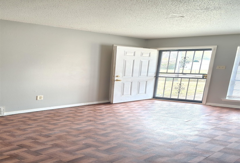 Empty room with a healthy amount of sunlight and a textured ceiling