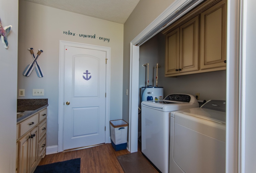 Clothes washing area featuring separate washer and dryer, dark hardwood / wood-style flooring, cabinets, and a textured ceiling