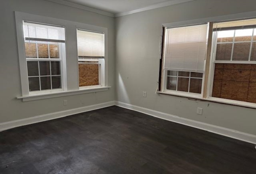 Empty room with crown molding and dark hardwood / wood-style floors