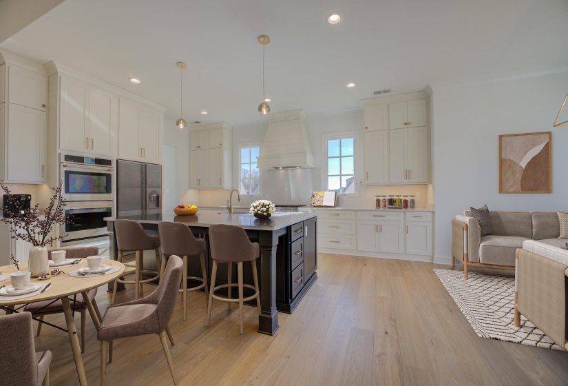 A bright and inviting eat-in kitchen featuring sleek stainless-steel appliances, elegant quartz countertops, and modern soft-close cabinets. The space is designed for both style and functionality, with ample natural light.