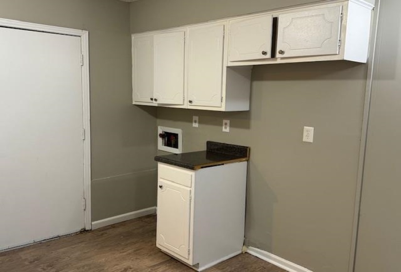 Kitchen featuring white cabinets and dark wood-type flooring