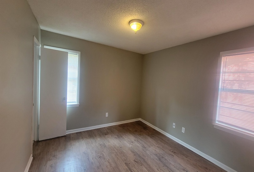 Unfurnished room with light hardwood / wood-style flooring and a textured ceiling