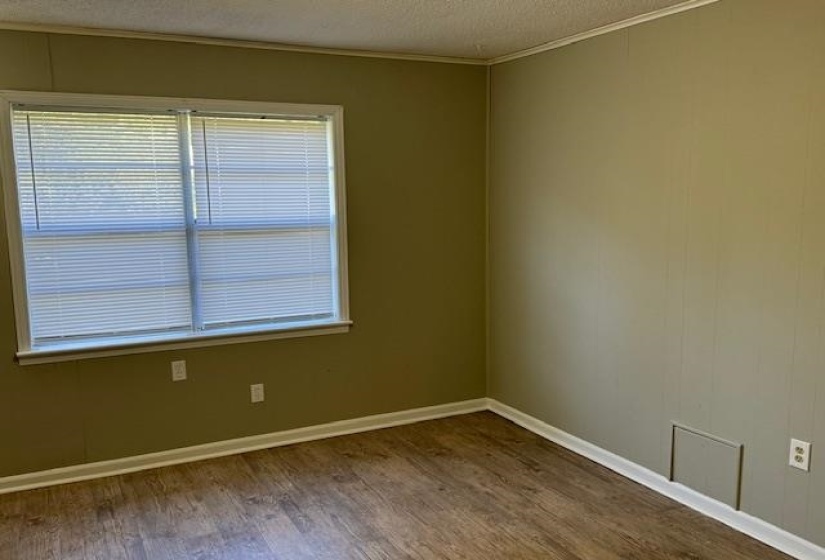 Spare room with a textured ceiling, hardwood / wood-style floors, and crown molding