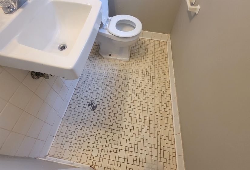 Bathroom with toilet, a shower, tile patterned floors, and sink