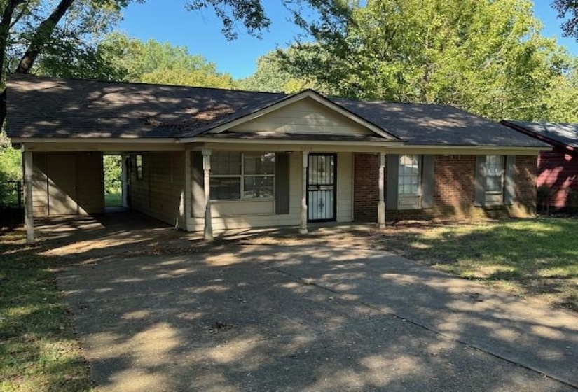 Single story home with a porch and a carport