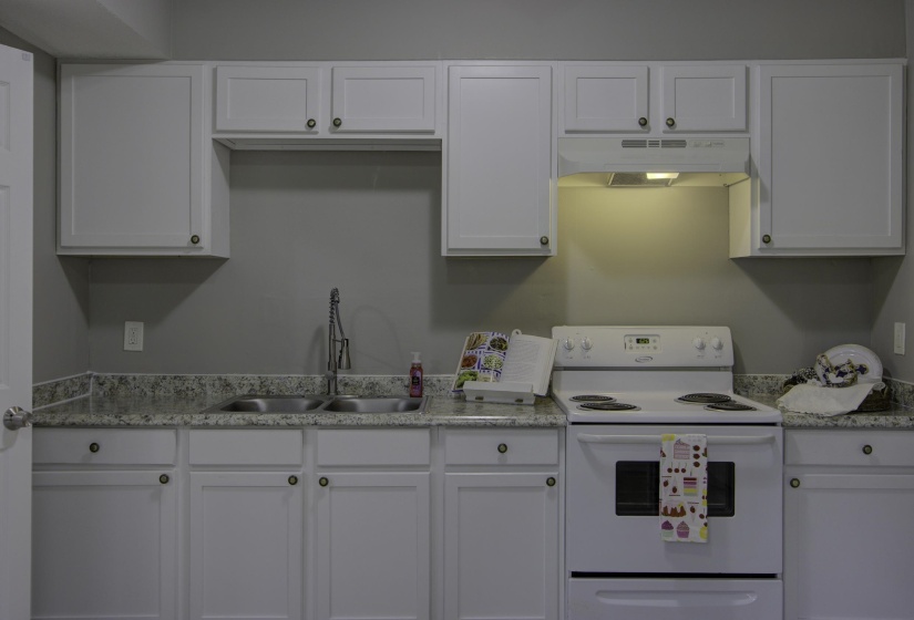 Kitchen with sink, white cabinetry, and electric stove