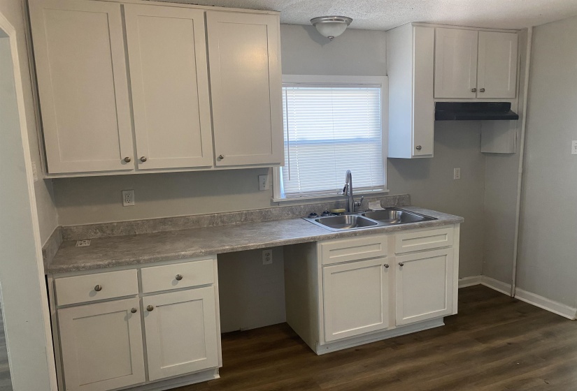 Kitchen featuring white cabinetry, sink, dark hardwood / wood-style floors, and a textured ceiling
