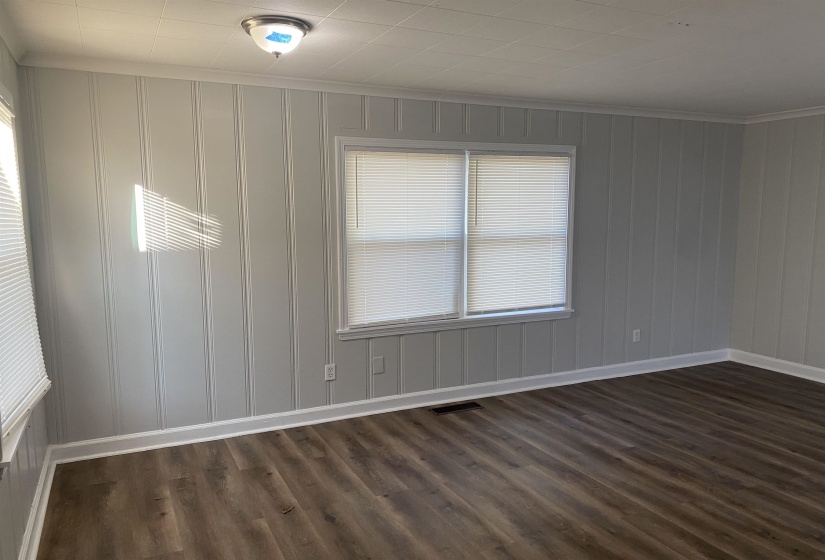 Empty room with crown molding and dark hardwood / wood-style flooring