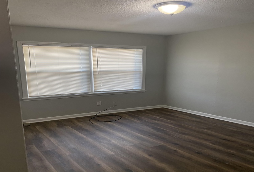 Spare room featuring a textured ceiling and dark wood-type flooring