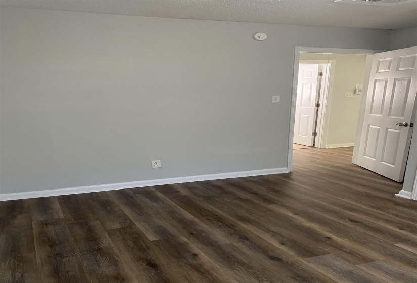Spare room with dark wood-type flooring and a textured ceiling