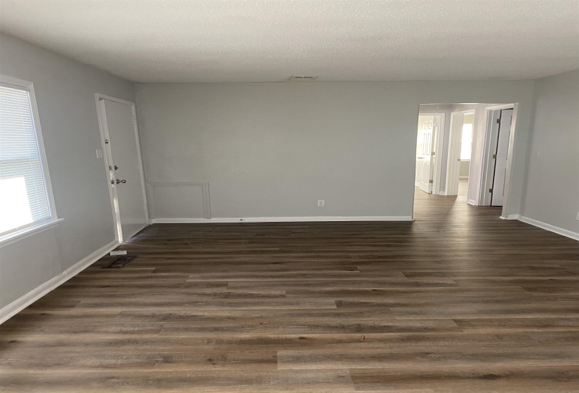 Empty room featuring dark hardwood / wood-style floors and a textured ceiling