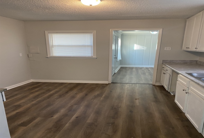Kitchen with white cabinets, dark hardwood / wood-style flooring, and a textured ceiling