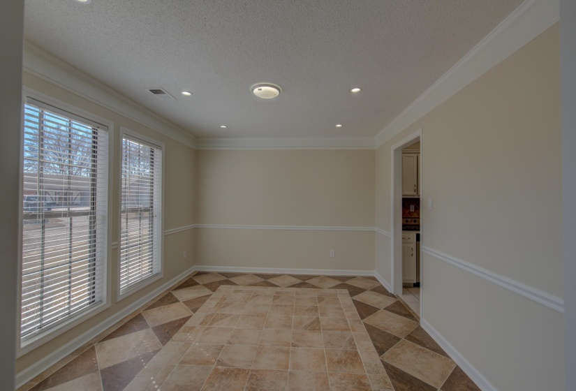Spare room featuring a textured ceiling, ornamental molding, and light tile patterned flooring
