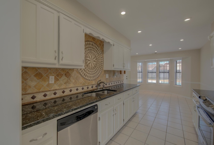 Kitchen featuring white cabinetry, dishwasher, sink, tasteful backsplash, and electric stove