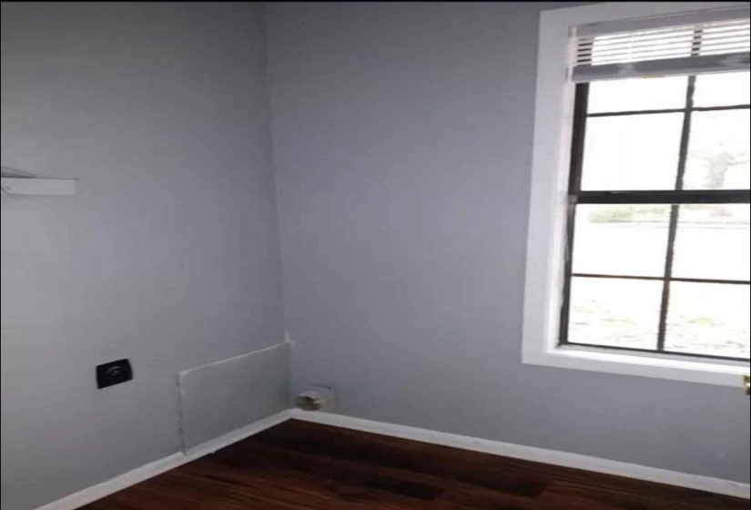 Empty room featuring dark hardwood / wood-style flooring